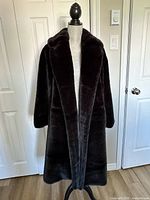 Front view of black faux fur coat on mannequin