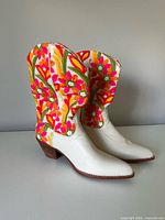 Side view of pair of white leather western boots with colourful floral embroidered shafts