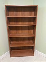 Front view of brown laminate bookcase with five shelves