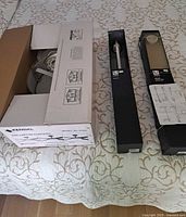 All three boxed items on bed: Kendal ceiling light, Umbra towel bar, Umbra towel ring