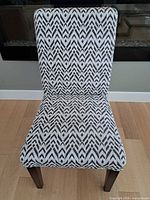 Front view of upholstered dining chair showing patterned fabric and condition
