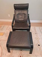 Front view of IKEA Poäng armchair with footstool showing overall design and condition
