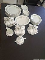Full set of plates, bowls, cups, creamer, sugar and serving pieces laid out