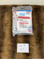 Front view of sealed DuPont Tyvek coverall pack on surface