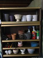 shelving with multiple planters, tools and sprays