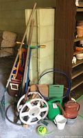 Group of assorted garden tools and accessories leaning against wall