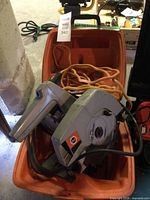 Circular saw in orange case with extension cord visible