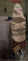 Ironing board with cover, basket of clothespins, box holding iron