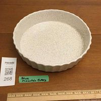 Top perspective showing full dish, speckled glaze, fluted rim and size reference