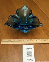 Top view of blue/teal freeform art glass bowl with ruler for scale
