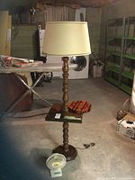 Floor lamp with table, shade, fan at base, clock on table