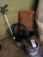 overview of tub with grabber, hoops, trays, yard bags, watering can