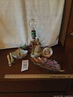 Group shot of all porcelain items on surface with ruler for scale