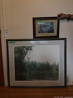 Both framed prints leaning against wall for size comparison