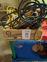 Crate containing multiple extension cords and trouble light