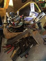 crate filled with assorted hand tools, gloves visible