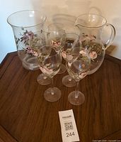 Entire seven-piece glass set on table showing floral designs