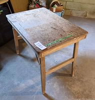 Angled overall view of wooden folding work table with legs extended