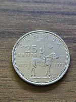 Reverse: mounted RCMP officer, denomination 25 cents, dates 1873-1973