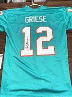 Full back view showing number 12, signature, size XL tag at collar