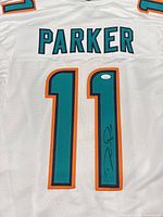 Front of white Miami Dolphins #11 jersey showing autograph on teal number