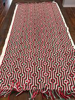 Full view of Afghan laid out on floor showing entire pattern and fringe