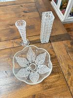 Top view of three pressed glass items on wooden table