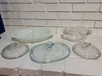 White divided casserole, clear bowl, three clear lids