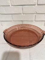 Top view of cranberry Pyrex pie dish showing scalloped rim and handles