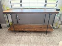 Front view of entire console table showing top, lower shelf, metal legs