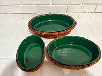 All three green ceramic dishes nested in their wicker baskets