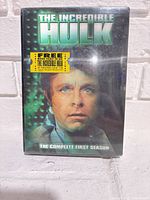 Front cover showing sealed box set with sticker and title