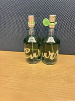 Front view of both Curve perfume bottles showing logo, liquid level, spray tops, and collars