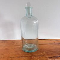 Full view of cylindrical aqua-tint bottle with stopper