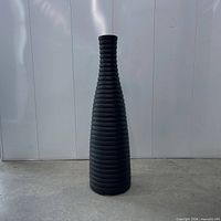 full view of tall ribbed matte black floor vase