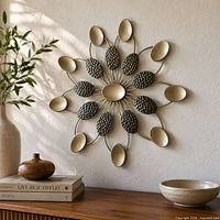 Front view of the champagne-gold metal sunburst wall sculpture mounted on wall
