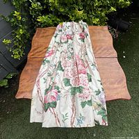 Single curtain panel displayed to show floral pattern and pleated header