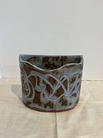 Front view showing semi-circular form, glaze, scroll relief