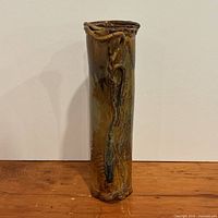 Full view of tall glazed pottery vase standing upright