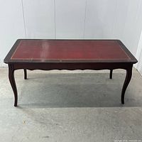 Full view of rectangular coffee table showing leather-style top and cabriole legs