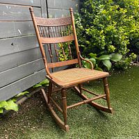 Full side-angled view of entire wooden rocking chair outdoors