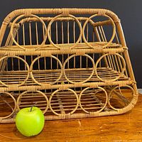 Front view showing three tiers and circular design with apple for scale