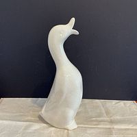 front view of tall white ceramic bird with crackle glaze