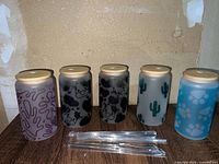 Front view of all five tumblers with lids and straws displayed