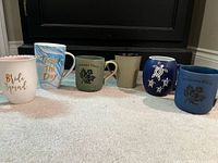 All six mugs in one frame, showing colours and graphics