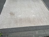 Full view of beige/cream area rug showing overall condition and stains