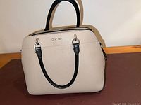 Front view of beige-taupe Calvin Klein satchel with black handles and silver hardware