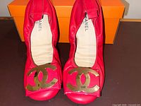 Top view of both red Chanel ballet flats with gold CC logo hardware displayed