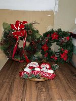 Overall view of two wreaths and basket sign