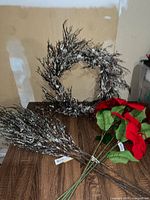 wreath, flocked twig picks, poinsettia stems on table